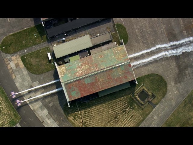 Two Planes Fly Through a Hangar – Red Bull Barnstorming