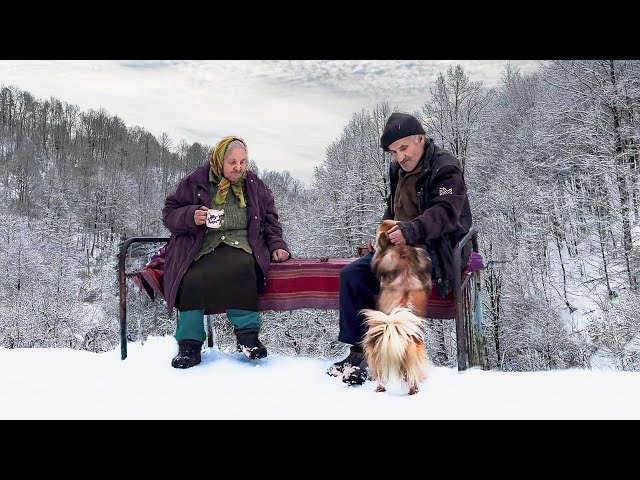 Happy old age of an elderly couple in a mountain village in winter far from civilization