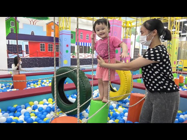 Baby and sister at indoor playground for kids with many toys color - nursery rhymes for babies