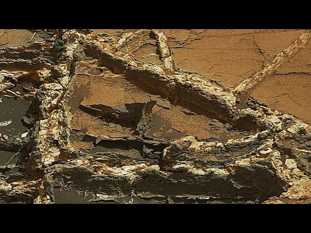 Crystalline treasures beneath weathered scars. Crystal shard veins on Mars