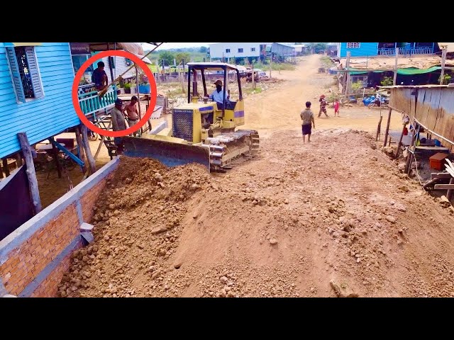 Team Dump truck wheel 10 unloading soil in Home Foundation pushing by bulldozer komat'su D31
